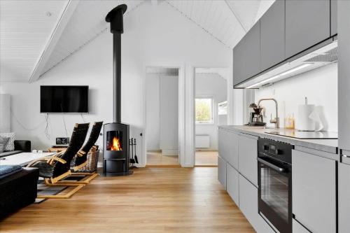 a kitchen with a living room with a fireplace at N102-Karrebaeksminde-Krageholmsvej-82 in Enø By