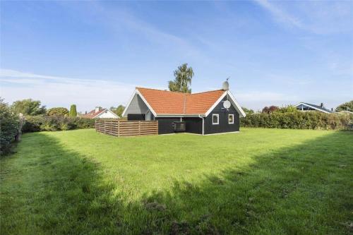 a black house with an orange roof on a green field at N102-Karrebaeksminde-Krageholmsvej-82 in Enø By
