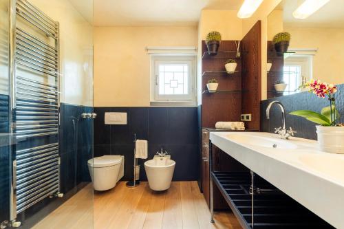 un bagno con un water e un lavandino di VILLA NINFEO 10&4, Emma Villas ad Arezzo