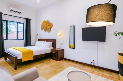 a bedroom with a bed and a tv on the wall at Amaryllis Residences Mount Pleasant in Blantyre