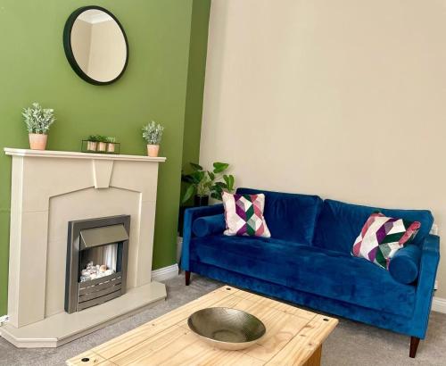 un salon avec un canapé bleu et une cheminée dans l'établissement 3-Bed Home Close to City Centre, Stadium & Baltic, à Newcastle upon Tyne