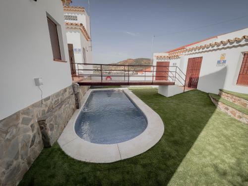 a swimming pool in the backyard of a house at Suites Neade Residencial in Sanlúcar de Guadiana