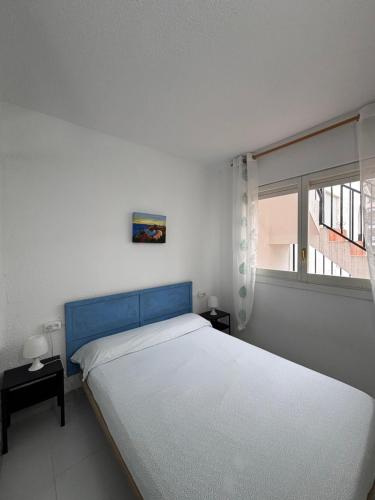une chambre avec deux lits et une fenêtre dans l'établissement Peñiscola apartamento con piscina, barbacoa y wifi, à Peñíscola