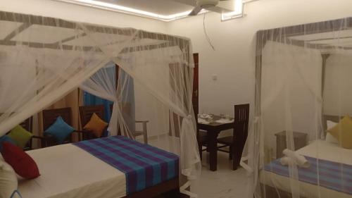 a bedroom with a canopy bed and a table at Villa 307 8 room 22 guest appartment in Matara
