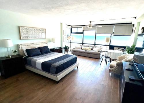 a bedroom with a bed and a living room at Spectacular Oceanfront Studio w/kitchenette in Daytona Beach