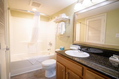 a bathroom with a sink and a toilet and a mirror at Bay View Resort Myrtle Beach in Myrtle Beach