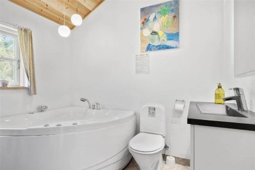 a white bathroom with a tub and a toilet and a sink at N106-Karrebaeksminde-Krageholmsvej-97 in Enø By