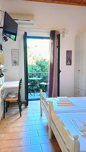 a bedroom with a bed and a desk and a window at Skardamoula's Studios n Apartments in Kardamili