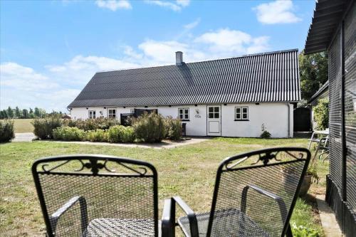 two chairs sitting in front of a white house at N159-Karrebaeksminde-Kirkebakken-40-B in Karrebæksminde