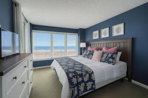 une chambre avec un lit aux murs bleus et une fenêtre dans l'établissement Atlantic Dunes - 101, à Myrtle Beach