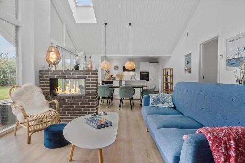 Una sala de estar con un sofá azul y una chimenea. en N329-Karrebaeksminde-Krageholmsvej-58, en Enø By