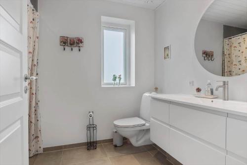 Un baño blanco con inodoro y espejo. en N329-Karrebaeksminde-Krageholmsvej-58, en Enø By