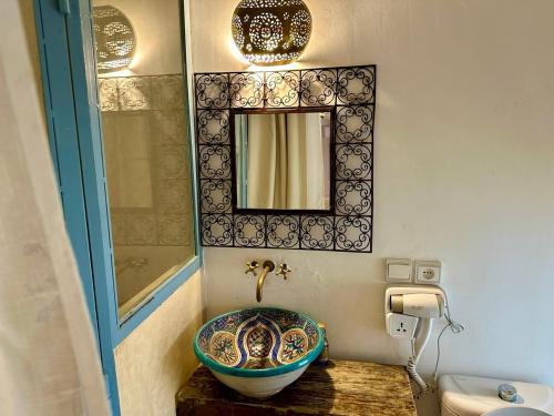 ein Badezimmer mit einem Waschbecken und einem Spiegel in der Unterkunft Riad Dar Malwan Hotel and Massage in Marrakesch