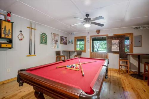 a pool table in a room with a ceiling fan at Cowboy Cabin - Creekside Firepit, Pool Table, Games + Large Screened-In Porch in Aska