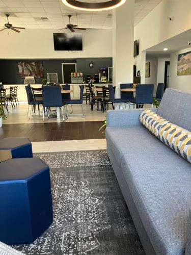 a waiting room with a couch and tables and chairs at Best Western Of Walterboro in Walterboro
