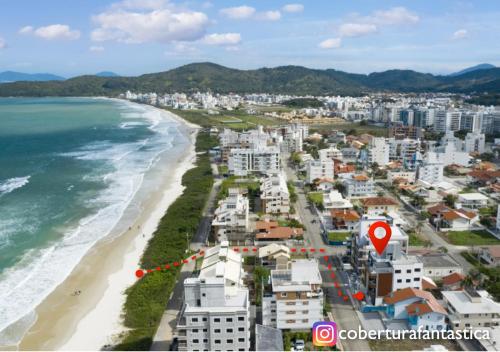 an aerial view of a beach with a city and the ocean at Fantástica cobertura apenas 70 metros da praia in Governador Celso Ramos