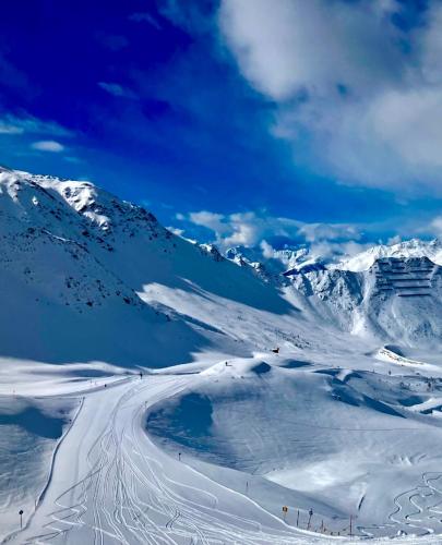 a snowy mountain with people skiing down a snow covered slope at Gästehaus Schneeberger in Matrei in Osttirol