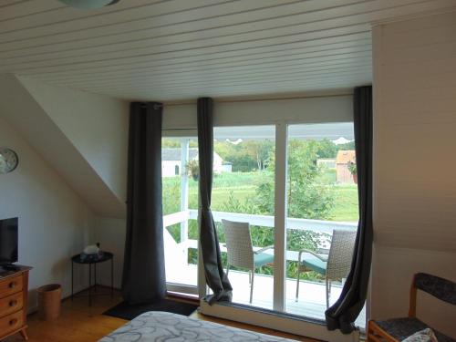 a bedroom with a window with a view of a balcony at Dutchies-dk in Væggerløse
