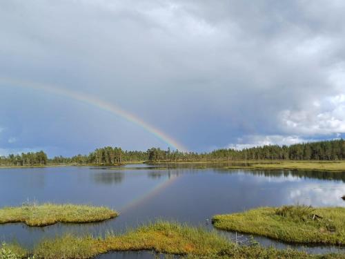 a rainbow over a lake with islands in the water at Centrally located holiday home in Stöllet in Stöllet