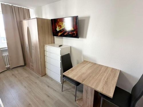 a room with a desk and a dresser with a tv on the wall at Beautiful apartment in Bergkamen bei Dortmund in Bergkamen