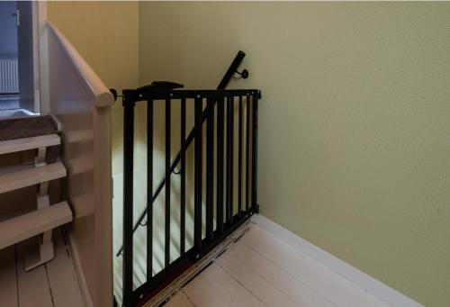 a staircase with a black railing in a room at Hanzestekje Harderwijk in Harderwijk