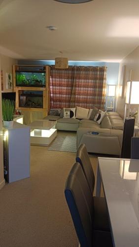 a living room with a couch and a table at Spacious Cheltenham Flat with Free Allocated Parking in Cheltenham