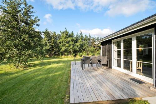 a wooden deck with a table and chairs on a house at JB130-Fjerritslev-Thorup-Strandvej-274 in Torup Strand