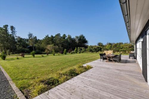 a patio with a table and chairs and a field at JB241-Fjerritslev-Lyngstien-25 in Torup Strand