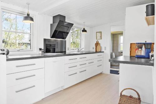 a white kitchen with white cabinets and a microwave at JB323-Fjerritslev-Markstien-21 in Torup Strand
