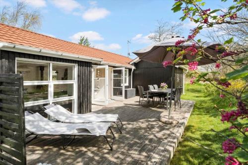 a patio with a table and chairs and an umbrella at JB323-Fjerritslev-Markstien-21 in Torup Strand