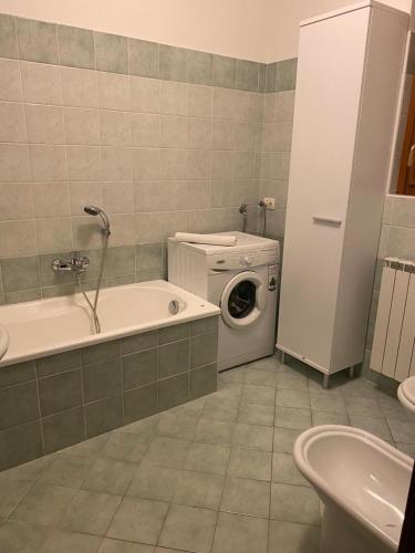 a bathroom with a washing machine and a washer at La Fontana apartments in Fiumelatte