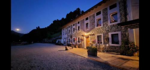 a building with lights on the side of it at night at Agriturismo La Casa Nei Boschi in Colderù