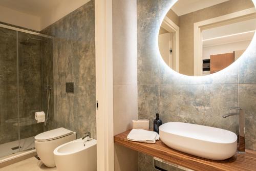 a bathroom with a sink and a toilet and a mirror at Da Lucia - Moderno Trilocale vicino al Centro e alla Spiaggia in Capo dʼOrlando