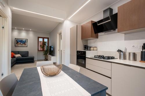 a kitchen and living room with a table in a room at Da Lucia - Moderno Trilocale vicino al Centro e alla Spiaggia in Capo dʼOrlando