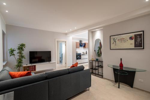a living room with a couch and a tv at Da Lucia - Moderno Trilocale vicino al Centro e alla Spiaggia in Capo dʼOrlando