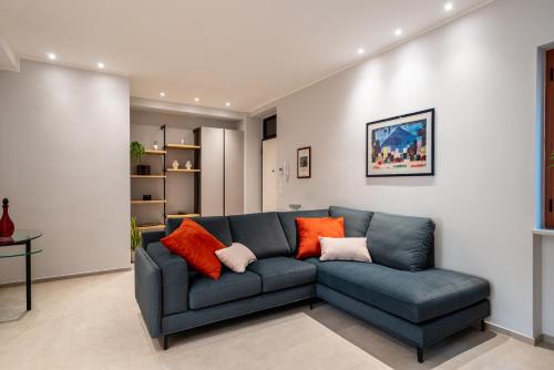 a living room with a blue couch with orange pillows at Da Lucia - Moderno Trilocale vicino al Centro e alla Spiaggia in Capo dʼOrlando