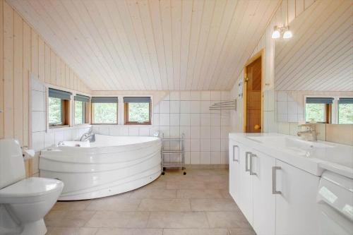 a large white bathroom with a tub and a toilet at JB193-Fjerritslev-Blabaerstien-78 in Torup Strand