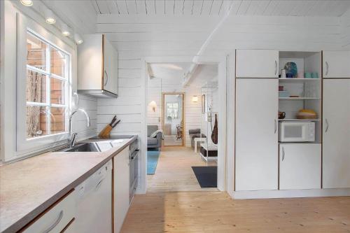 a kitchen with white cabinets and a sink at JB160-Fjerritslev-Skovstien-7 in Torup Strand