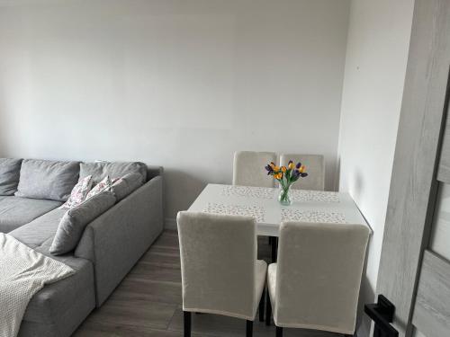 a table and chairs and a couch in a living room at Apartament 2 pokojowy w Centrum Miasta in Żagań