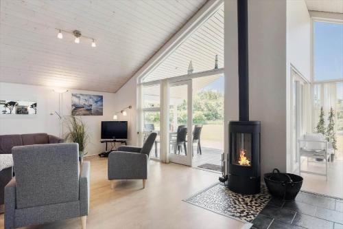 a living room with a fireplace and a couch at JB326-Brovst-Kronvildtvej-134 in Tranum