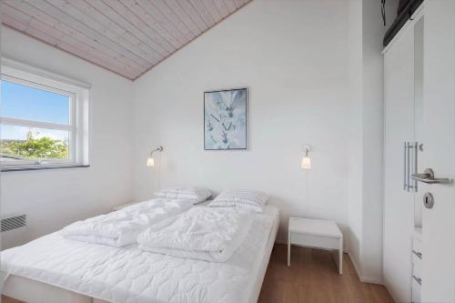 a white bedroom with a bed and a window at JB326-Brovst-Kronvildtvej-134 in Tranum