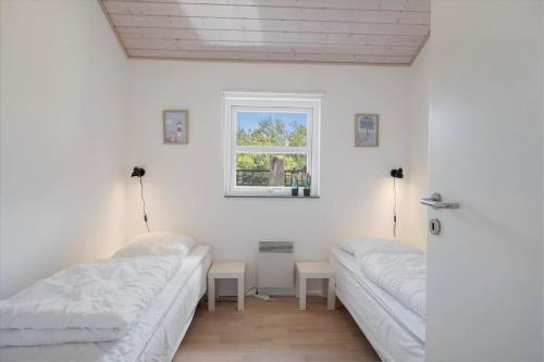 two beds in a white room with a window at JB326-Brovst-Kronvildtvej-134 in Tranum