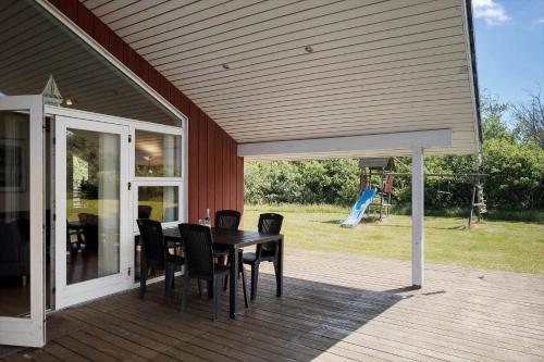 a patio with a table and chairs on a deck at JB326-Brovst-Kronvildtvej-134 in Tranum