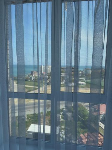 a window with a view of the ocean and buildings at Квартира с Видом на Море, жк Парус, 9-3 in Chornomorsk