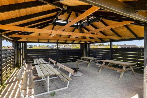 a group of benches sitting under a pavilion at JB208-Brovst-Kronvildtvej-8 in Tranum