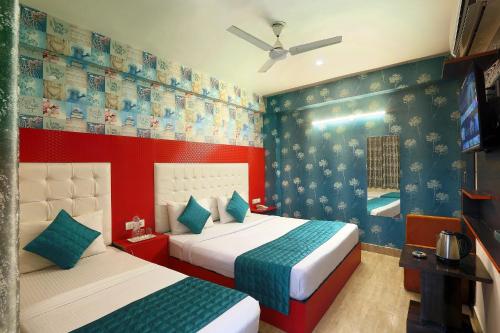 a bedroom with two beds and a tv in it at Hotel Paradise Park At Airport in New Delhi