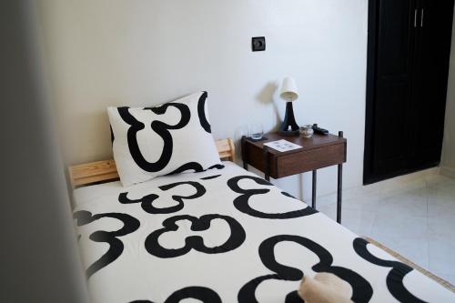 a bedroom with a bed with a black and white blanket at Al Mohit Hôtel Dakhla in Dakhla