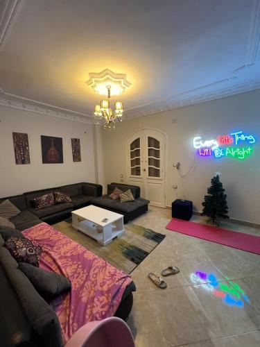 a living room with a couch and a sign on the wall at Private and cosy place to stay in Kafr Rāshid