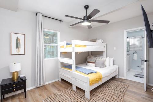 a bedroom with a white bunk bed and a ceiling fan at Mountain Top Retreat in Canyon Lake