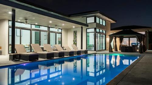 a swimming pool with chairs and a gazebo at The Mansion One and Only Luxurios 8 000 ft Villa in Melalevca Isles